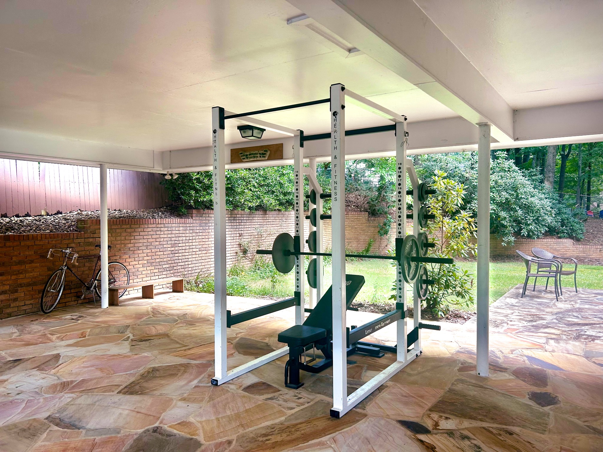 Covered outdoor training area at Trailhead House with a weight rack and bench